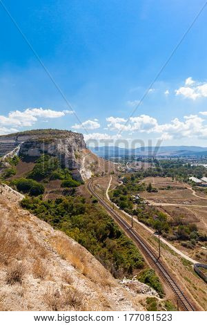 Railway in mountainous landscape and Zagaytanskaya rock, Inkerman, Crimea, Russia