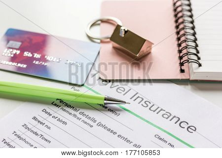 Traveling concept with insurance application form, notebook and credit cards on white table background