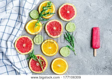 homemade citrus popsicles with fresh fruit slices on stone table background top view