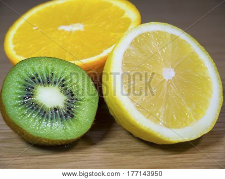 Halves of lemon kiwi and an orange