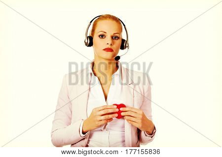 Unhappy call center woman holdinh heart model