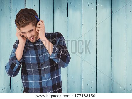 Digital composite of Man with headphones against wood panel