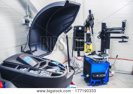 Garage equipment for mounting and balancing wheels of cars