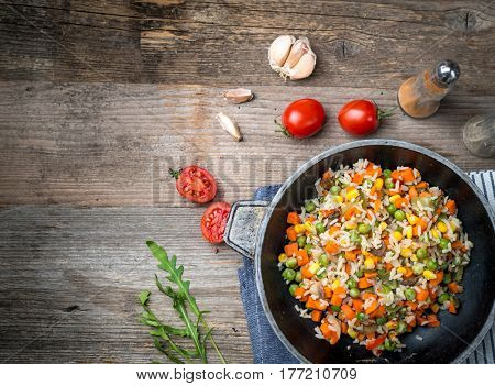 Cooked and ready eastern pilaf with vegetables and corn, additional textspace left on side, topview