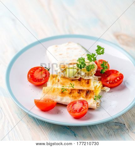 Nice and ready to eat shaurma or sandwich with cut in half tomatoes nearby, topview