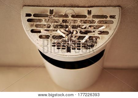 Trash bin with cigarettes butts, indoor