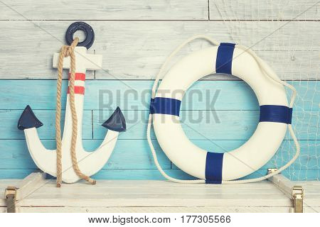 Anchor and lifeline against the background of blue-white boards. Coloseup
