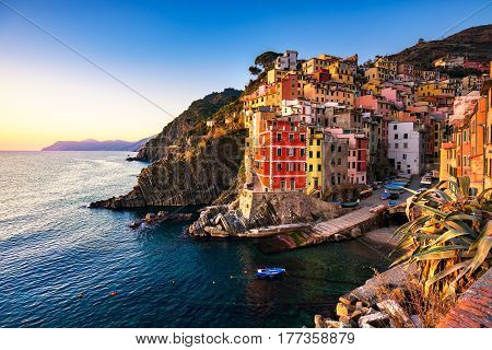 Riomaggiore town cape and sea landscape at sunset. Seascape in Cinque Terre National Park Liguria Italy Europe.
