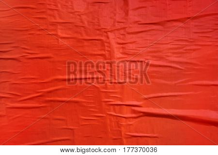 Printed red poster paper texture crumpled billboard material glued to a wall useful as background