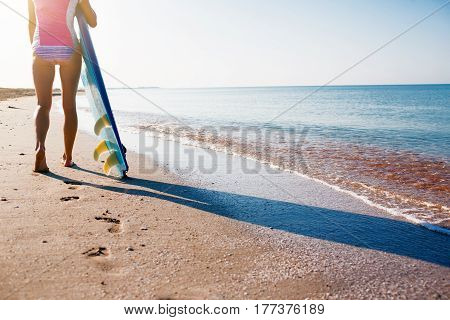 Surfer girl on the beach waiting for waves