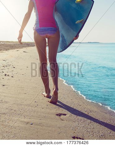 Surfer girl on the beach waiting for waves