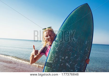 Surfer girl on the beach waiting for waves