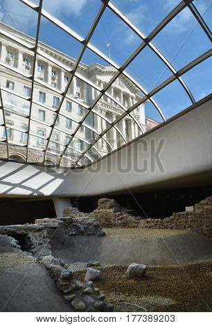 Sofia Bulgaria - October 18 2016: The ruins of the ancient fortress Serdika under a glass dome and a view of the building of the Council of Ministers in Sofia Bulgaria.
