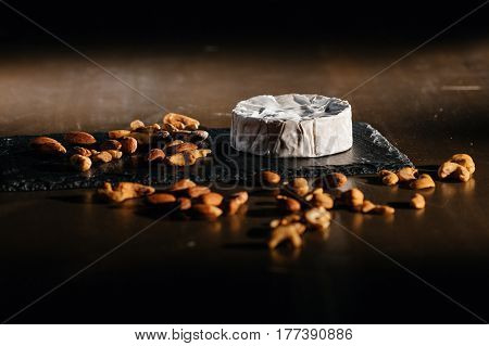 Cheese with nuts in wooden table background