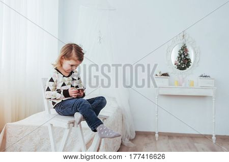 Child In Soft Warm Pajama Playing In Bed