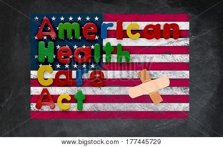Childs magnetic letters spell American Health Care Act in congress. This is superimposed on a US flag chalked onto a blackboard with a bandage