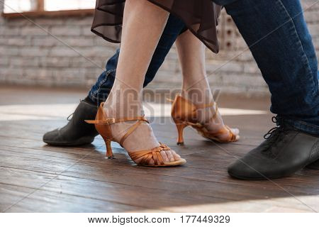 Improving technique. Professional talented creative dance couch teaching elderly woman salsa while dancing and demonstrating new step