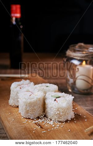 Japanese food sushi roll with crab sesame seeds cucumber cheese on a wooden board svea in the background