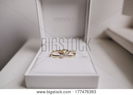on white windowsill in the white box are three wedding rings