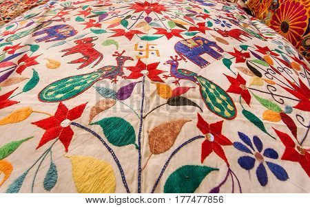 Beautiful birds and animals on surface of vintage textile colorful bedspread. Old asian market design