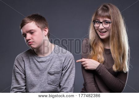 Sneering young woman and man on gray background