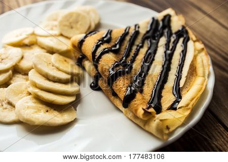 breakfast pancake crepe with banana wooden background