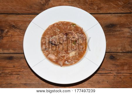 Delicious plate of soupy rice on a wooden table