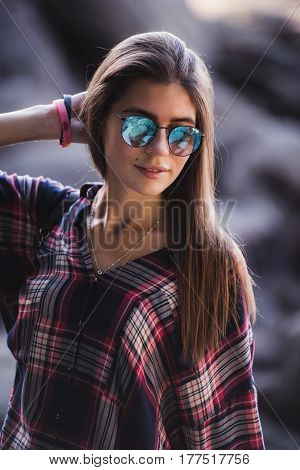 Outdoor fashion image of stylish young lady, fashionable.Lifestyle portrait of stunning hipster girl, wearing elegant glamour shirt dress and vintage sunglasses.