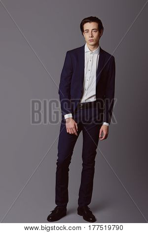 Business fashion man wearing blue suit with white shirt. Studio shot against grey. Processed with VSCO s3 preset