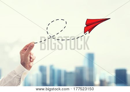 Businessman holding a small paper plane on cityscape background . Startup working enterprise concept