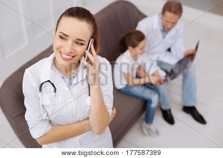 This is great. Delighted nice dedicated doctor smiling while calling her little patients mother for explaining her great progress of her daughter