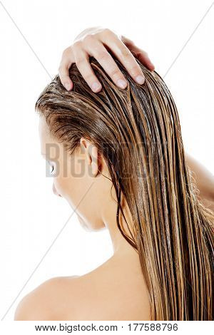 Photo of woman applying hair conditioner.