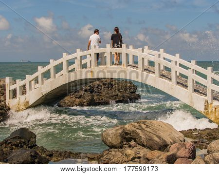 Shimen Taiwan - October 03 2016: A white bridge between the rocks on the shore of the ocean in Shimen Art northern Taiwan