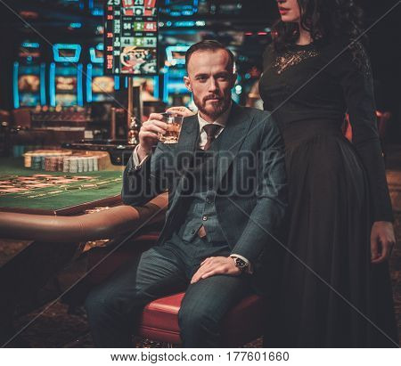 Upper class friends gambling in a casino.