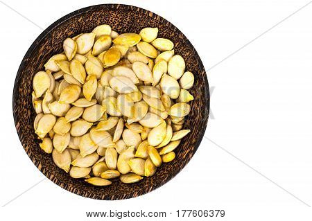 Dry uncooked pumpkin seeds in wooden bowl. Studio Photo