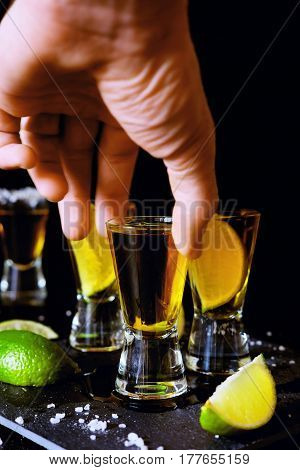 Strong alcohol drinks. Tequila glass shots in the bar with salt and lime slices.