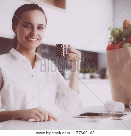 Young woman planning expenses and paying bills on her kitchen