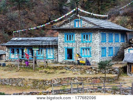 Stone Building at remote Lodge in Himalaya Mountains decorated by traditional buddhist prayer flags. Kothey Lodge, Nepal, Solo-Khumbu region, November 2, 2016