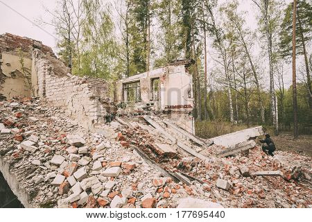 Re-enactor Dressed As Russian Soviet Crew Soldier Of World War II Performing Mopping-up Operation Among Wreckage Of Destroyed Building.