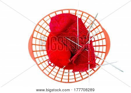 Knitting needles, a red woolen thread in a tangle and needlework on white background. Wool yarn