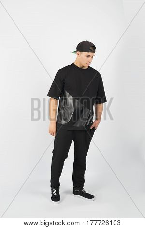 Young muscular man wearing black clothes and snapback with sneakers isolated on white background