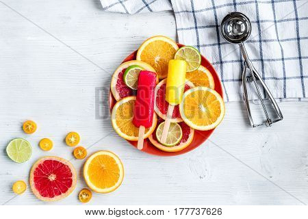 homemade ice-cream with sliced oranges and lime on stone table background top view mockup