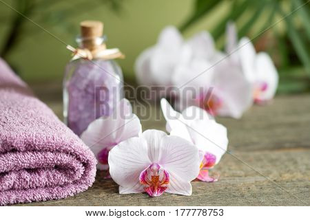 Spa still life with bath salt towel and orchids on wooden boards