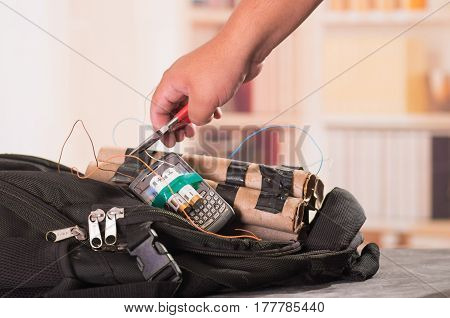 Close up shot of hands cutting wires with pliers of an improvised explosive device bomb