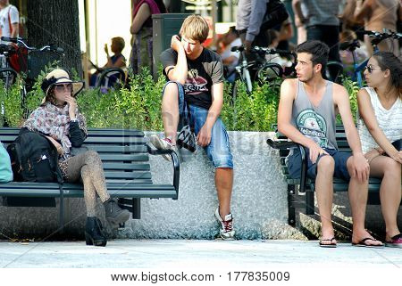 Oslo Norway - July 22 2014: teenagers relax in the park Eidsvolls Plass located on the main street Karl Johans Gate