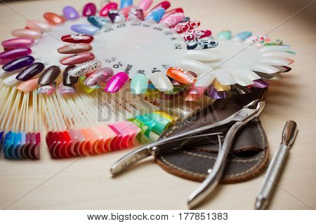 Table full of manicure utensils, manicure tools, nail polish colours on palette. Nails art accessories white.
