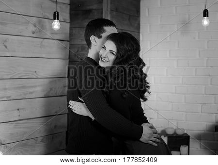 Man and woman are hugging. Happy woman hugging her husband. Happy couple at his new appartament. Black and white photo. Happiness concept.