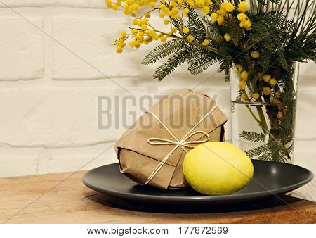 Easter yellow egg with mimosa spring flowers and craftpaper heart box