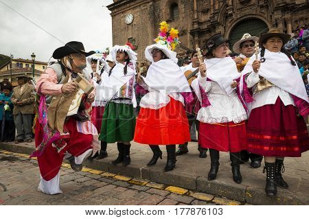 Cuzco Peru - December 25 2013: People wearing traditional clothes and masks dancing the Huaylia in the Christmas day in front of the Cuzco Cathedral in Cuzco Peru.
