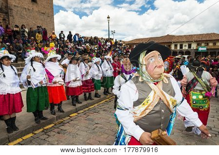 Cuzco Peru - December 25 2013: People wearing traditional clothes and masks dancing the Huaylia in the Christmas day in front of the Cuzco Cathedral in Cuzco Peru.